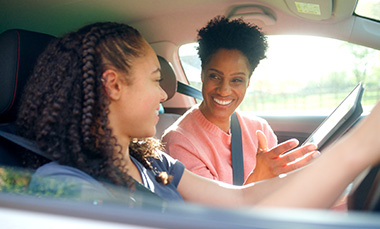 young woman teaching teen driving in car smiling and happy together learning to drive 2 people 2 smiles 2 moments