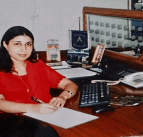 woman sitting at a desk writing with a keyboard and telephone visible in the background office setting professional environment