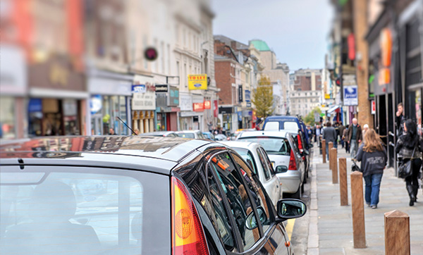 busy city street with parked cars and pedestrians walking nearby showcasing urban life and vehicle density