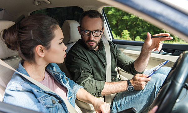 man giving driving instructions to woman in car emphasize safety skills for beginners and 7 essential tips